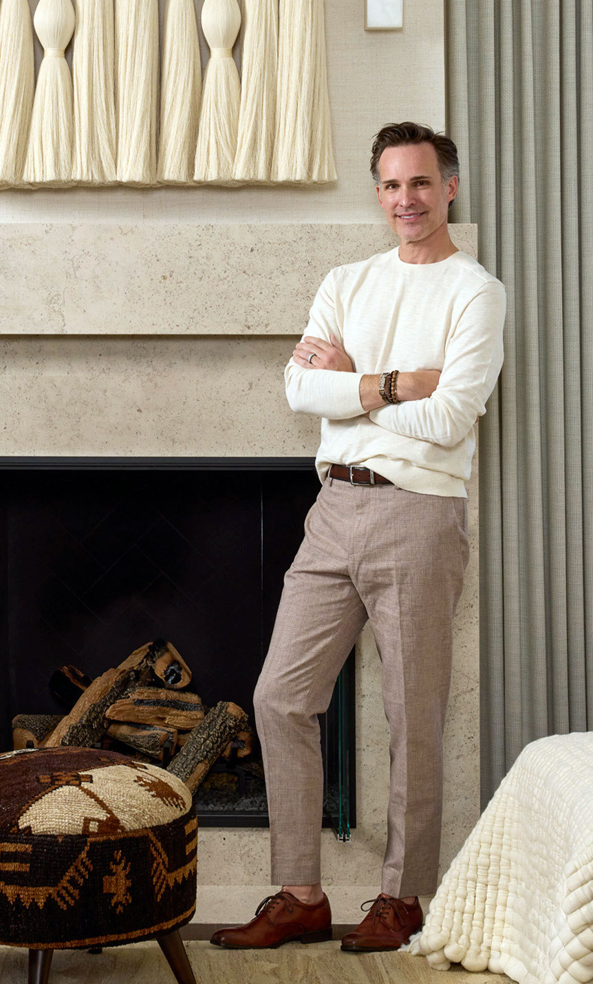 Troy-Riving-Portrait-Fireplace Chandra Marx, luxury interior design firm executive, sitting in a chair.